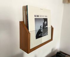 a wooden shelf holding several records and magazines