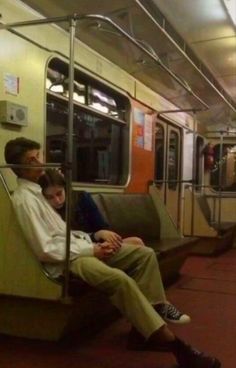 two people sitting on a subway train next to each other