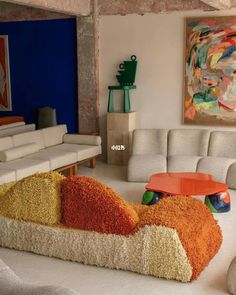 a living room filled with lots of white couches and colorful pillows on top of them