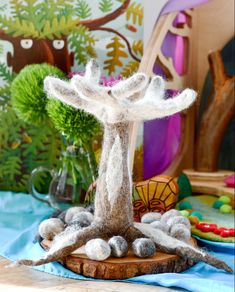 a wooden table topped with white and gray decorations next to a vase filled with flowers