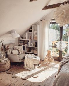 a living room filled with furniture next to a window covered in sun shining through the curtains