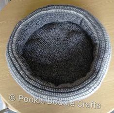 a black and white hat sitting on top of a wooden table