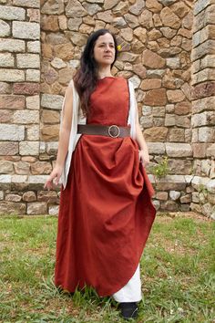 Sleeveless dress. Elegant and simple, she designed this historical medieval dress to show off her natural beauty and enhance her body with a belt. Used in larp clothing, sca, Renaissance Faires and more. With simple embellishments on the neckline and armholes, giving priority to the shape of the dress. Inspired by the twelfth century, where the clothing consisted of wearing a chemise and a dress open on the sides to the hip. It will be girded by a belt at the waist. The upper dress was shorter than the inner one. The chemise hugged the body while the dress gave volume to the hips.   The neckline of this medieval dress is round. It is not a tight dress, in the early years of the Middle Ages, both men and women wore this loose garment. The beauty of this dress is in the flight of the skirt j Fitted Medieval Dress For Summer, Fitted Medieval Summer Dress, Fitted Medieval Style Summer Dress, Bohemian Linen Medieval Dress For Larp, Elven Dresses For Medieval Festivals, Bohemian Dresses For Larp, Fitted Linen Dresses For Larp, Medieval Style Dress For Summer Larp, Medieval Summer Dress For Larp