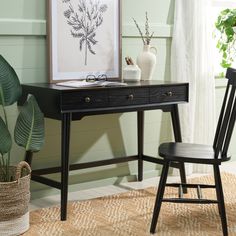 a black desk and chair in front of a window with a plant on the table