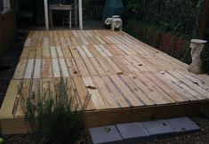 a wooden deck in the middle of a yard