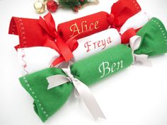 three personalized christmas stockings with bows and ribbons on the top one is red, white and green