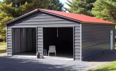 a large garage with a red roof and two chairs in the driveway area next to it