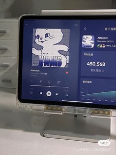 a computer monitor with an animated cat on it's screen and other electronic devices in the background