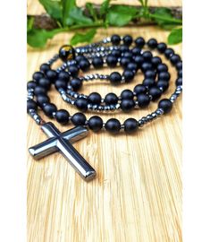 Natural Matte Black Onyx Cross Necklace Pendant. Black Onyx and Hematite Stones Beads. Christian Catholic Christ Rosary. Religious Prayer Beads. Crucifix. Mens Jewelry. Religious gift. Onyx provides us with strength and promotes vigor.  It helps us with steadfastness and stamina and imparts self-confidence. It centers our being and aligns us with our higher power, providing us with focus, dedication, and self-control.  As a grounding stone, it helps stimulates our power to make wise decisions an Black Hematite Jewelry With 8mm Beads, Spiritual Hematite Necklace With Black Beads, Black Hematite Spiritual Jewelry, Black Hematite Round Bead Jewelry, Black Hematite Bead Jewelry, Black Hematite Round Beads Jewelry, Spiritual Black Cross Beaded Necklace, Black Cross Jewelry With 8mm Beads, Black Hematite Beaded Necklaces With Round Beads