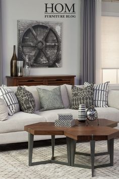 a living room filled with furniture and pillows on top of a white couch next to a coffee table