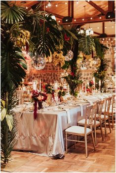 a table set up for an event with flowers and greenery