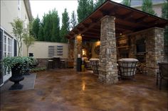 an outdoor kitchen and dining area with stone pillars