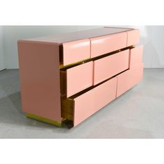 a pink and gold dresser with three drawers