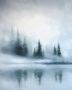 a foggy lake with trees in the background