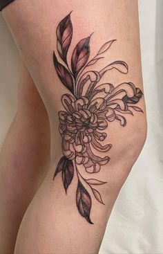 a woman's thigh with a flower tattoo on it