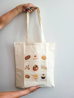 "PLEASE VISIT MY WEBSITE FOR MORE PRODUCTS! www.snapturethis.ca  The perfect lightweight reusable tote bag for coffee essentials (duh), markets, shopping, or just carrying your everyday essentials! This would make an amazing gift for a sweet treat / pastry lover! I worked with the incredible illustrator Jules (@heyoitsjules goodwellstudio)  on the original print.  Details:  Size: 15\"w x 16\"h Fabric Type: 5oz Canvas Fabric Handle: 12\" long handle Print Style: Heat Transfer  Care For Details: Hand wash cold (preferred) or cold wash on delicate cycle. DO NOT PLACE IN DRYER. Instead, let it air dry by placing it on a flat surface and realigning the straps so they don't dry wrinkled. Canvas material shrinks when you wet it, please avoid washing often and instead spot clean as needed.  How to Large Everyday Canvas Gift Bag, Daily Canvas Tote Bag For Gifts, Coffee Essentials, Pop Up Market, Gift Totes, Graphic Tote, Coffee Gifts, Bag Canvas, Reusable Grocery Bags