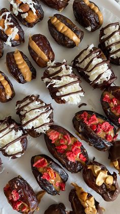 chocolate covered doughnuts are arranged on a platter with white frosting and toppings