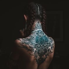 the back of a woman's body with tattoos on her upper and lower back