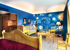 a bedroom with blue walls and yellow furniture in front of a painting on the wall