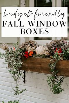 a window box filled with flowers and greenery next to a brick wall that says budget - friendly fall window boxes