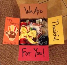 an open box filled with candy and handprinted thank you notes on the inside