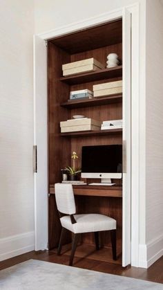 a desk with a computer on top of it in front of a bookshelf