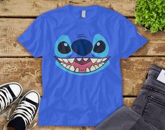 a blue t - shirt with an image of a cartoon character's face on it