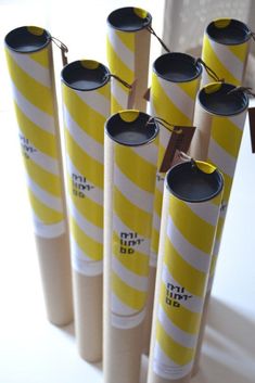 several candles are arranged in the shape of tubes with writing on them and string attached to each tube