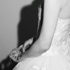 black and white photograph of a woman in a wedding dress with tattoos on her arm