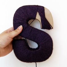 someone is knitting the letter s with yarn