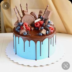 a chocolate cake with berries, raspberries and chocolate on top is sitting on a table