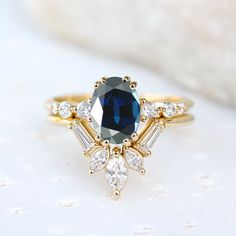 a blue and white diamond ring sitting on top of a table