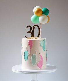 a birthday cake with balloons and the number 30 on top is decorated in pastel colors