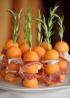 small oranges are arranged in the shape of balls with meat and vegetables on them