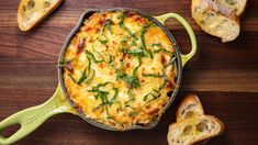 a casserole with cheese and green onions in a cast iron skillet on a wooden table