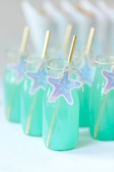 there are some little jars with straws in them and starfish decorations on the top