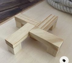 a wooden cross sitting on top of a table next to a rope