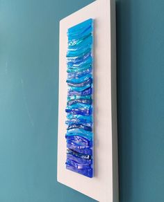 a blue piece of art hanging on a wall