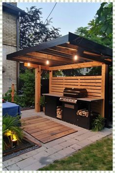 an outdoor bbq grill with lights on it and some plants in the back yard