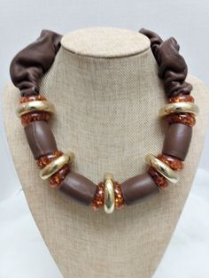 Here is another unique boho necklace from Italian designer, Wilma Spagli.  The necklace features chocolate brown leather tube beads and donut rings in burnt orange confetti and gold.  The necklace also has scrunched brown leather leading to the stamped lobster claw clasp.  The necklace measures 20 inches. Luxury Brown Hand-strung Necklaces, Adjustable Brown Jewelry With Large Beads, Brown Jewelry With Wooden Beads, Adjustable Brown Necklaces, Vintage Brown Jewelry, Gold Donuts, Donut Ring, Marble Necklace, Boho Statement Necklace