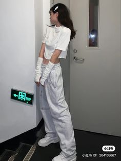 a woman standing in front of a door with her hands on her hips and wearing white gloves