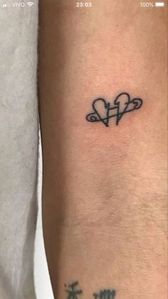 a small tattoo with two hearts on the arm