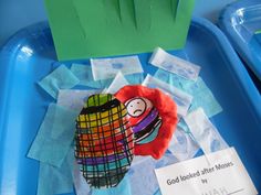 a child's art project is displayed on a blue tray with tissue paper and scissors