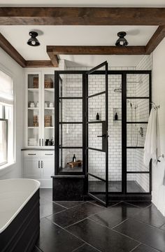 a black and white tiled bathroom with glass doors