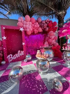 a table topped with lots of balloons and disco balls