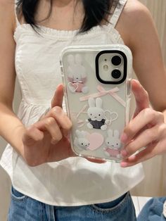 a woman holding up her phone case with mouses on it