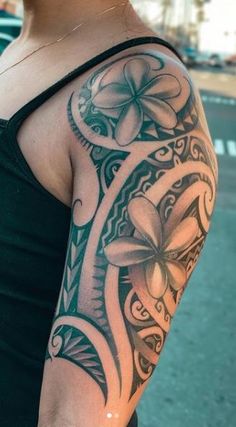 a woman's arm with an intricate tattoo design on the side of her shoulder