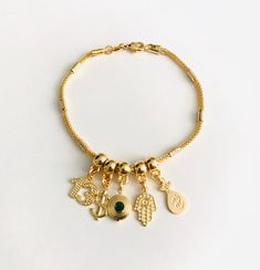 "18k gold filled charm bracelet, number 13, dollar sign, cz eye, hamsa hand, money bag. the charms are moving around the bracelet. 7.5\" long for good luck, money, protection, prosperity.. 18k gold filled pulsera de buena suerte. numero 13, signo del dolar, cz ojo, mano de fatima, bolsa del dinero. para prosperidad, dinero, proteccion, buena suerte. 7.5 \" largo los charm se mueven alrededor de la pulsera." Gold Plated Charm Bracelet With Dangling Charms, Gold Spiritual Charm Bracelet With Dangling Charms, Gold Spiritual Charm Bracelet For Good Luck, Good Luck Bracelet, Number 13, Dollar Sign, Charms Bracelet, Protection Bracelet, Evil Eye Pendant