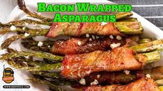 bacon wrapped asparagus on a white plate with the words bacon wrapped asparagus