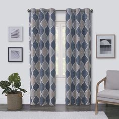 a living room filled with furniture and a large window covered in blue patterned curtains next to a white rug